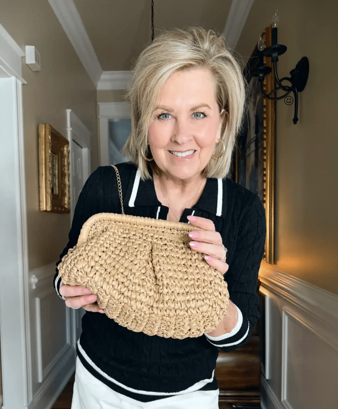 woman with black sweater holding a casual straw handbag